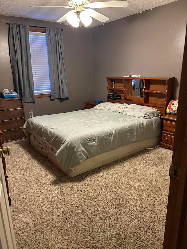 carpeted bedroom with a textured ceiling and ceiling fan