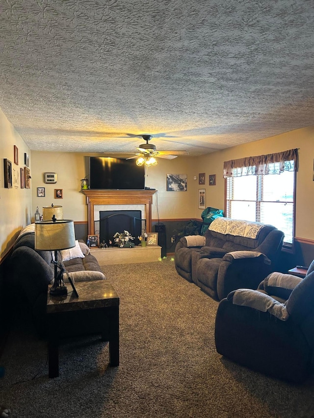 carpeted living room with ceiling fan and a textured ceiling