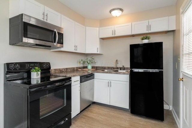 kitchen featuring sink, black appliances, light hardwood / wood-style floors, and white cabinets