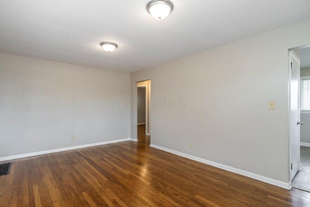 spare room featuring dark wood-type flooring