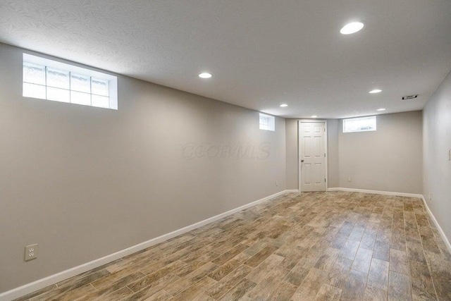 basement featuring wood-type flooring and plenty of natural light