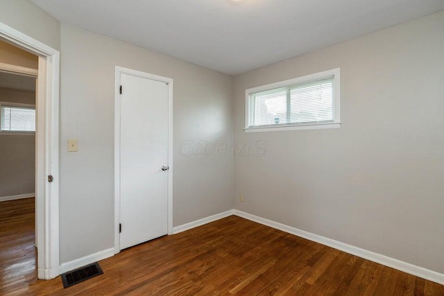 unfurnished room with hardwood / wood-style flooring