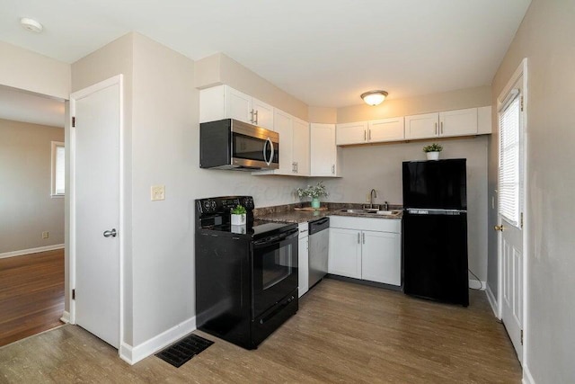 kitchen with white cabinetry, sink, hardwood / wood-style floors, and black appliances