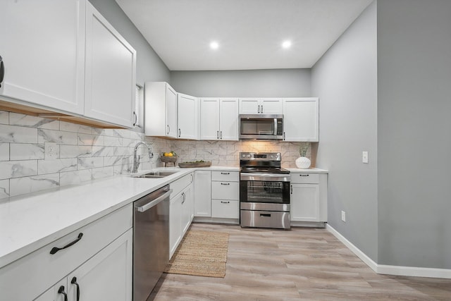 kitchen featuring stainless steel appliances, sink, and white cabinets