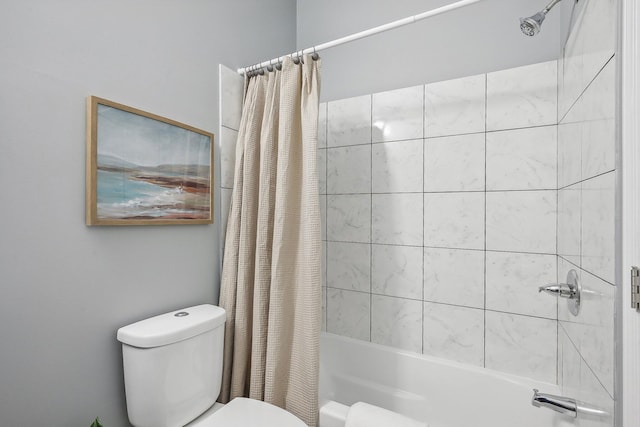 bathroom featuring shower / tub combo and toilet