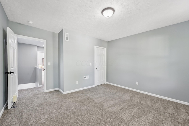 unfurnished bedroom with a textured ceiling and carpet