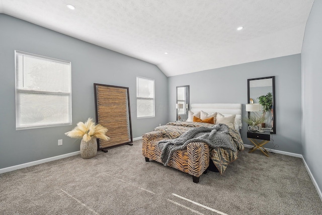 bedroom with vaulted ceiling, carpet floors, and a textured ceiling