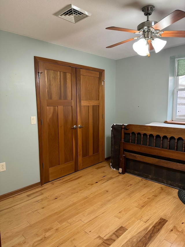 bedroom with a closet, ceiling fan, and light hardwood / wood-style flooring