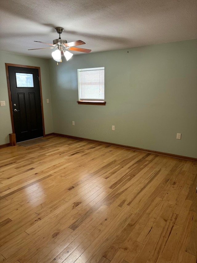 entrance foyer featuring ceiling fan, a textured ceiling, and light wood-type flooring