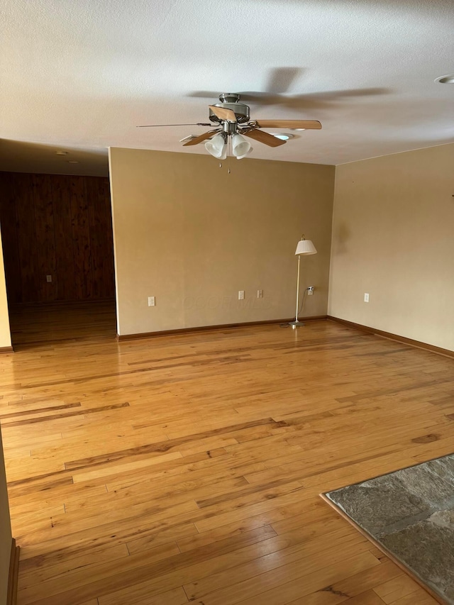 spare room featuring ceiling fan, light hardwood / wood-style flooring, and a textured ceiling