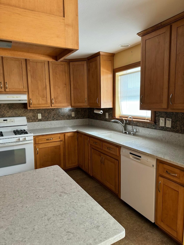 kitchen featuring sink, backsplash, and white appliances