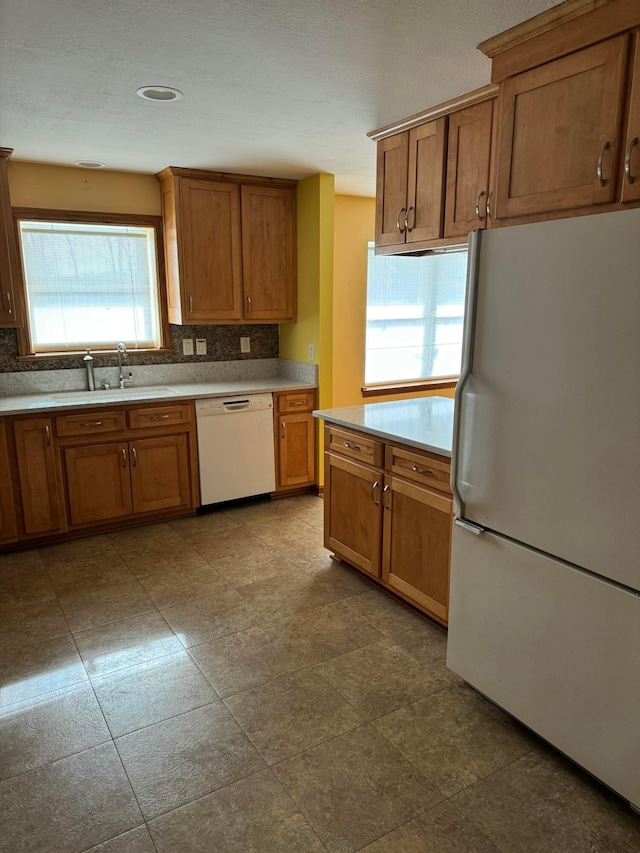 kitchen with sink, white appliances, and decorative backsplash