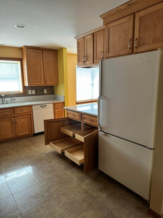 kitchen featuring sink, white appliances, and decorative backsplash