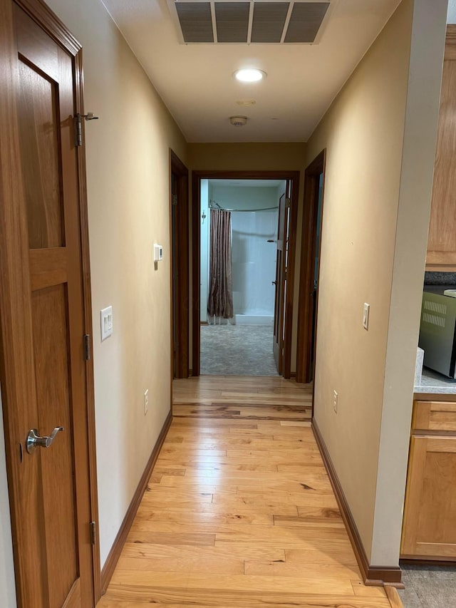 corridor with light hardwood / wood-style floors