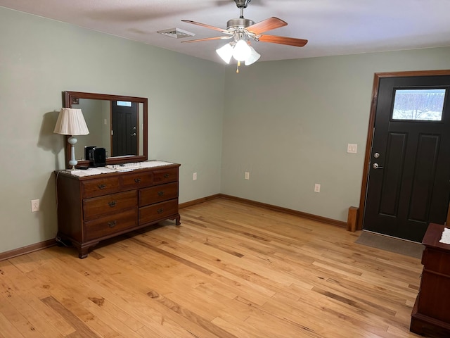 foyer entrance with ceiling fan and light wood-type flooring