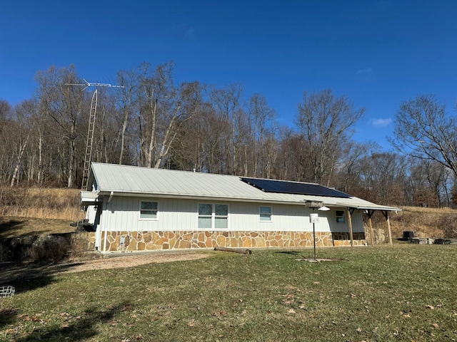 view of front of house featuring a front yard and solar panels