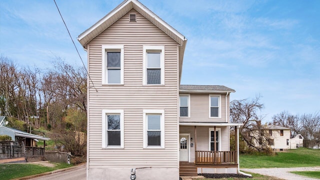 front facade with covered porch and a front lawn