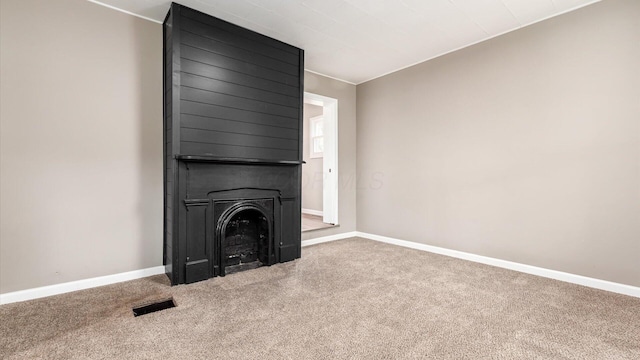 unfurnished living room with a fireplace and carpet