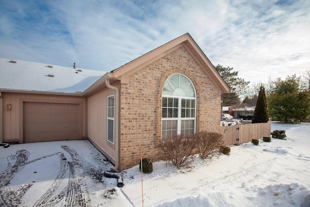 snow covered property featuring a garage