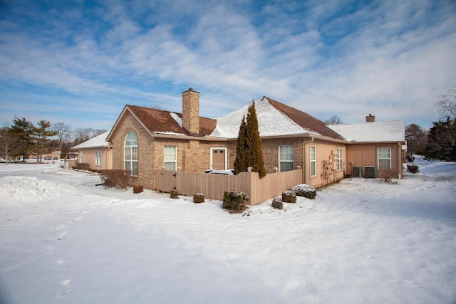 snow covered property with cooling unit