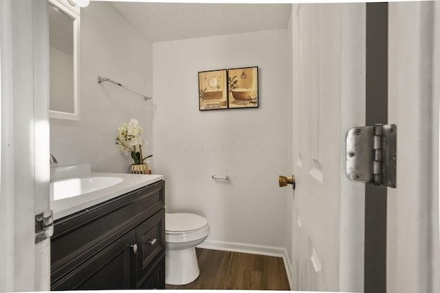 bathroom featuring hardwood / wood-style flooring, vanity, a textured ceiling, and toilet