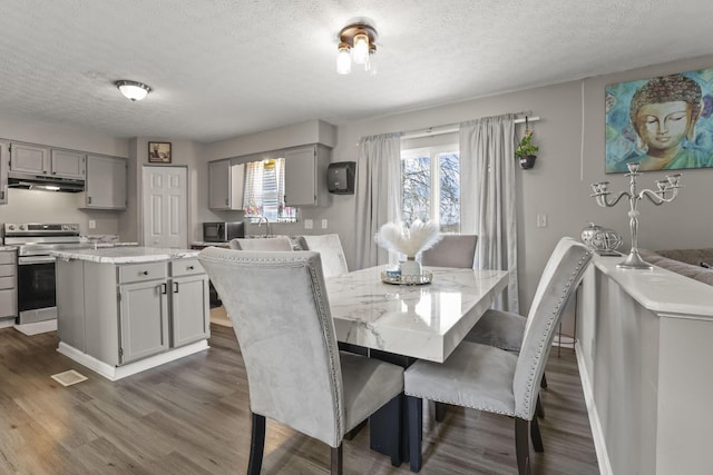 dining space featuring dark hardwood / wood-style flooring and a textured ceiling