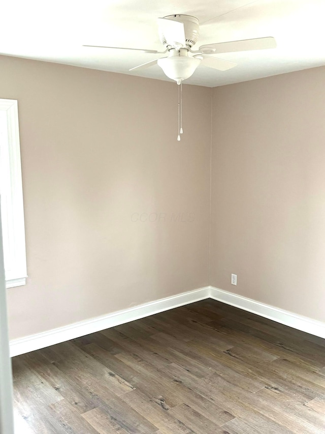 empty room featuring ceiling fan and dark hardwood / wood-style flooring