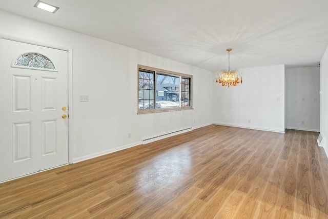 foyer entrance with an inviting chandelier, baseboard heating, and light hardwood / wood-style floors