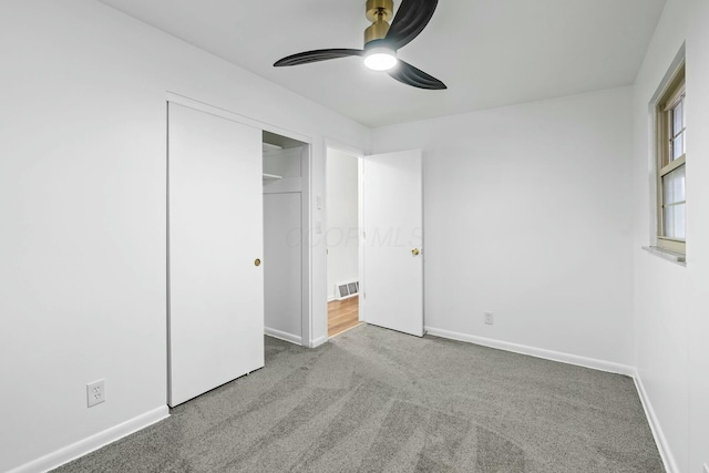 unfurnished bedroom with ceiling fan, light colored carpet, and a closet