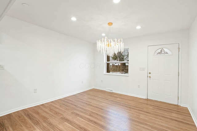 entryway with an inviting chandelier and light hardwood / wood-style floors