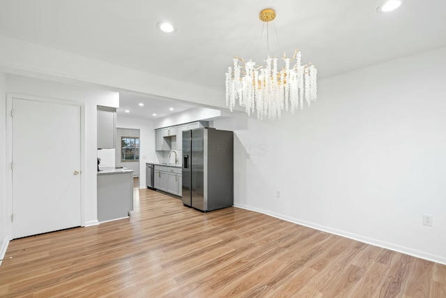 kitchen featuring stainless steel appliances, sink, light hardwood / wood-style flooring, and gray cabinetry