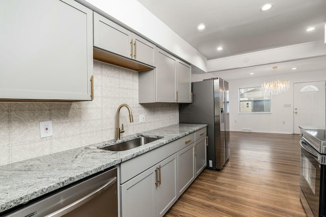 kitchen with gray cabinetry, sink, pendant lighting, and stainless steel appliances