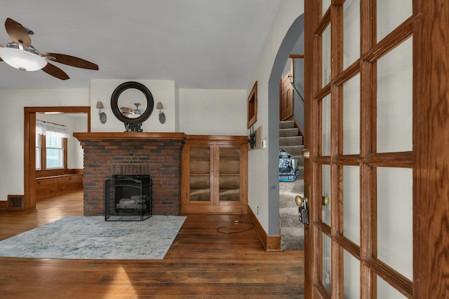 living room with a fireplace, dark hardwood / wood-style floors, and ceiling fan