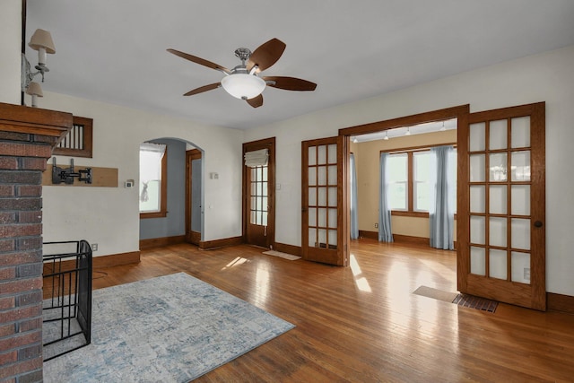 living room with hardwood / wood-style floors, ceiling fan, and french doors