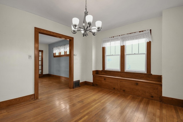 empty room featuring hardwood / wood-style flooring and a notable chandelier