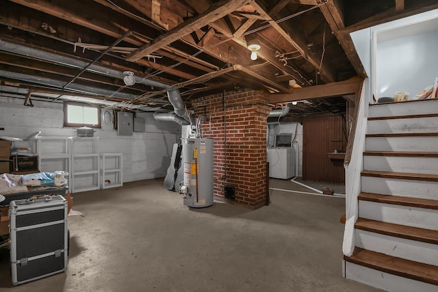 basement featuring electric panel, washing machine and dryer, and gas water heater