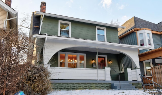 snow covered property featuring a porch