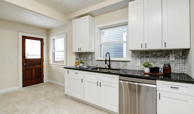 kitchen with tasteful backsplash, white cabinetry, dishwasher, sink, and dark stone countertops