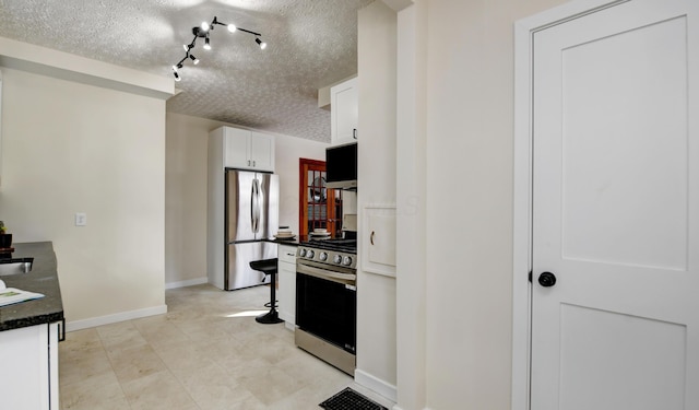 kitchen with stainless steel appliances, white cabinetry, and a textured ceiling