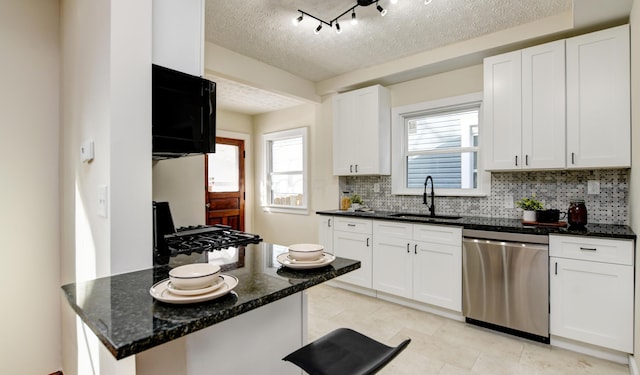 kitchen featuring sink, backsplash, white cabinets, a textured ceiling, and stainless steel dishwasher