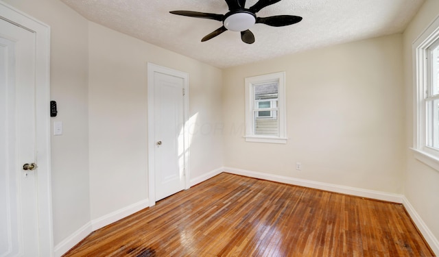 spare room with hardwood / wood-style floors, a textured ceiling, and ceiling fan