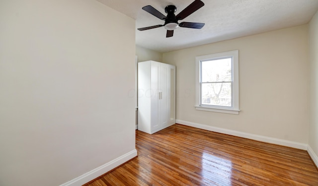 spare room with hardwood / wood-style flooring, ceiling fan, and a textured ceiling