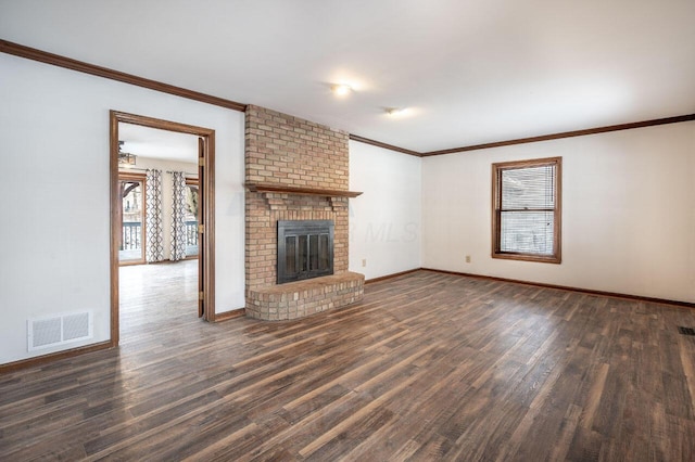 unfurnished living room with ornamental molding, a brick fireplace, and dark wood-type flooring