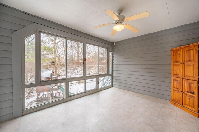 unfurnished sunroom featuring a wealth of natural light and ceiling fan