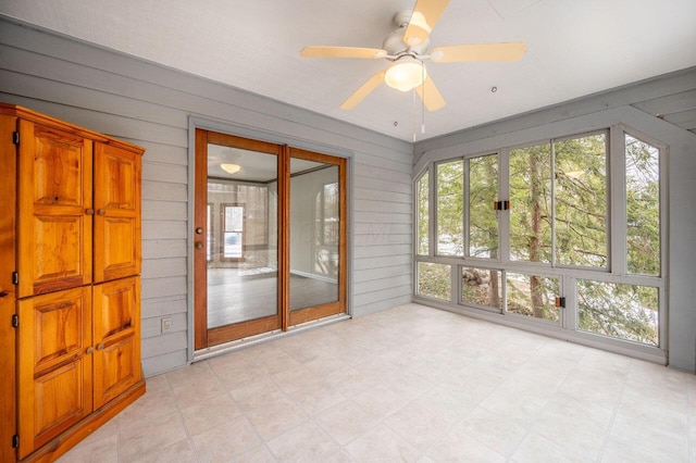 unfurnished sunroom with ceiling fan and a healthy amount of sunlight