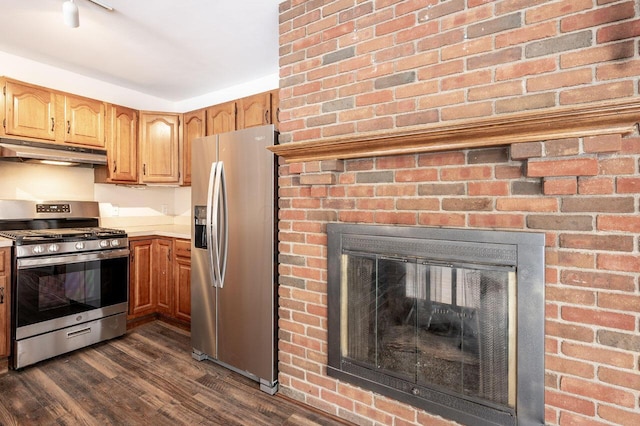 kitchen featuring dark hardwood / wood-style flooring, a brick fireplace, and stainless steel appliances