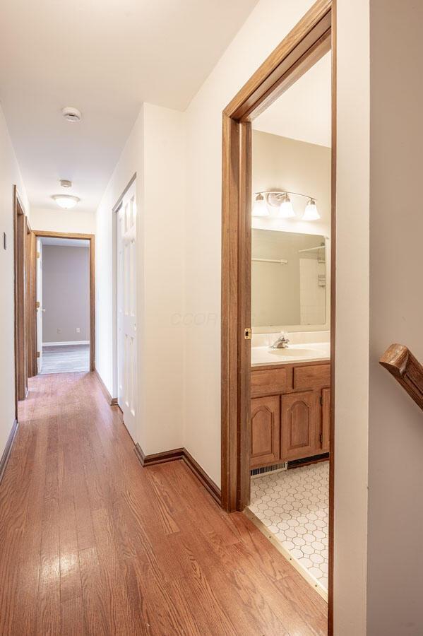 hall with sink and light hardwood / wood-style floors