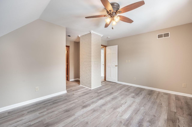 spare room with ornate columns, ceiling fan, lofted ceiling, and light hardwood / wood-style floors