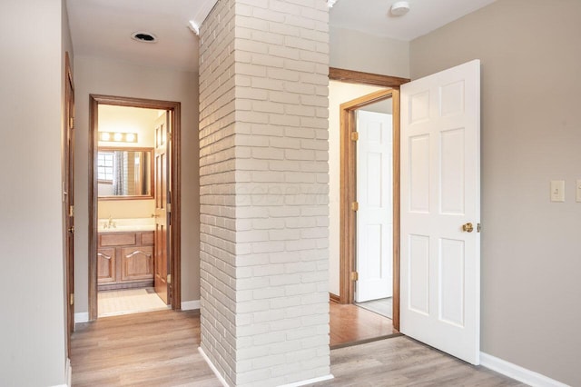 corridor with sink and light hardwood / wood-style floors