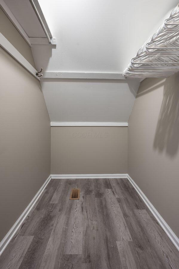 spacious closet featuring dark hardwood / wood-style flooring